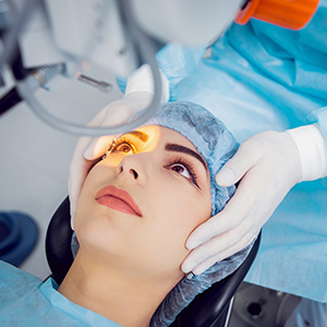 A woman receiving medical attention with an eye exam being performed in a clinical setting.